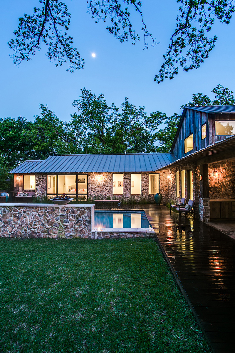 Stone walls and a large swimming pool under the night sky at a Dallas, Texas farmhouse