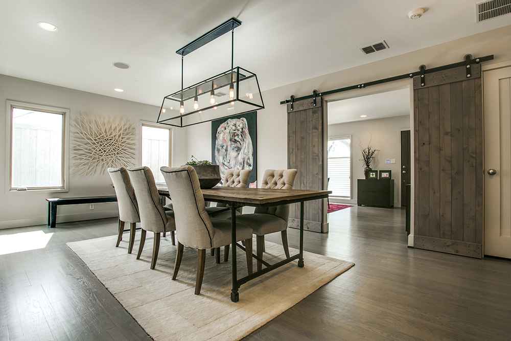 Elegant dining room at a rustic farmhouse in Dallas with farm doors